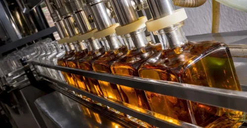 Alcohol and spirits bottling line for glass bottle filling, capping, and packaging